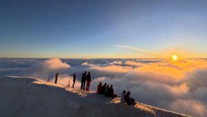 Alpinisti in vetta che osservano l’orizzonte sulle Alpi Mountaineers on the summit looking towards the horizon before their first 4000m peak